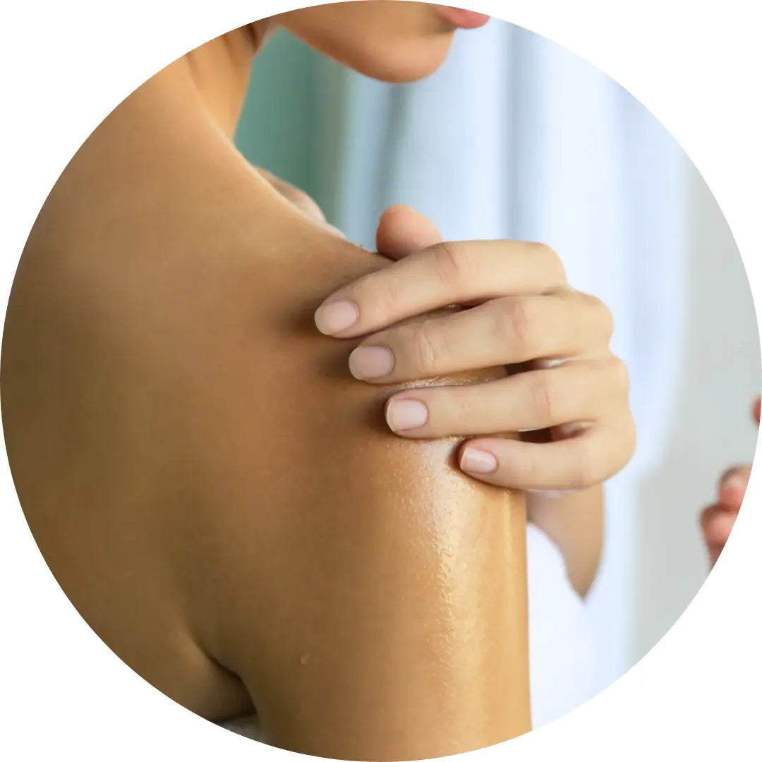 Woman using Buddha Beauty Vegan dry body oils on her shoulder 